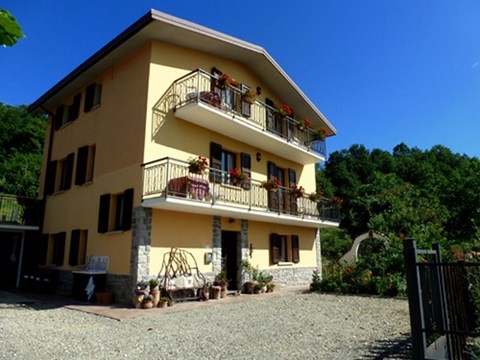 Casa Appennino, yellow three story chalet style house, with balconies